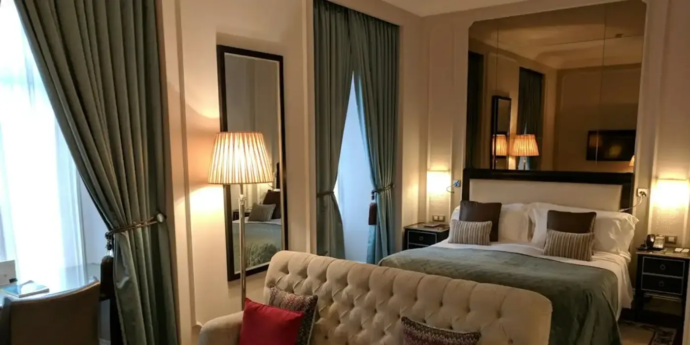 Habitación de hotel urbano con cama vestida y luz cálida